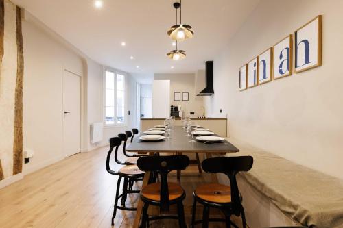 une grande salle à manger avec une longue table et des chaises dans l'établissement Cosy apartment - 4BR-12P - Canal Saint-Martin, à Paris