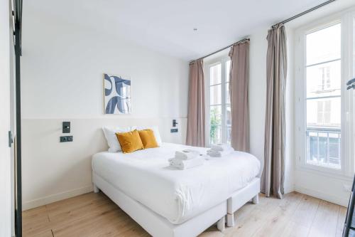 - une chambre blanche avec un lit blanc et des fenêtres dans l'établissement Cosy apartment - 4BR-12P - Canal Saint-Martin, à Paris