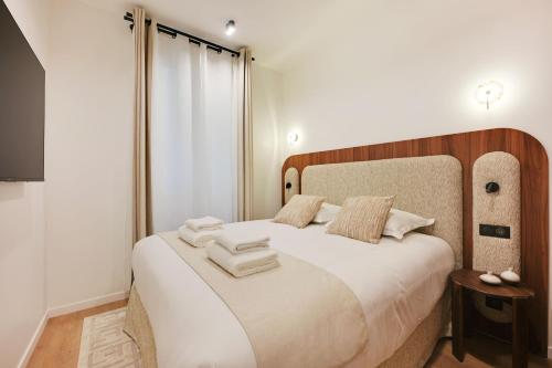 une chambre avec un grand lit avec des draps blancs dans l'établissement Chic apartment - 1BR-4P -AC- Marais-Vosges, à Paris
