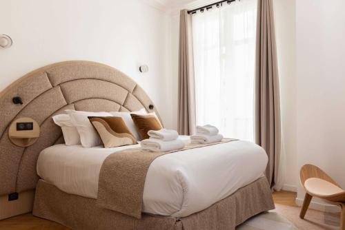 une chambre avec un grand lit avec des serviettes dessus dans l'établissement Cosy apartment - 3BR-6P - Montmartre-Sacré-Cœur, à Paris