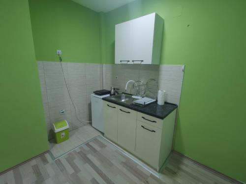 a small kitchen with a sink and a mirror at Apartman Kaoma in Soko Banja