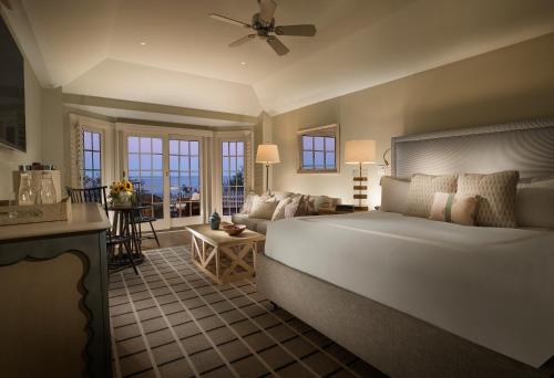 a bedroom with a large bed and a living room at Chatham Bars Inn in Chatham