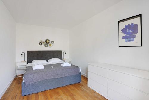 une chambre avec un lit dans une pièce blanche dans l'établissement Chic apartment - 1BR-4P - Next to Paris, à Saint-Ouen