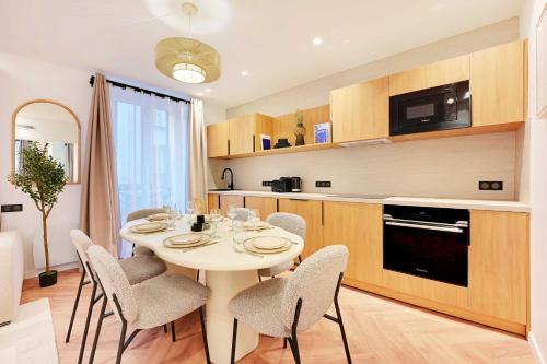 - une cuisine avec une table et des chaises blanches dans la chambre dans l'établissement Serene apartment - 2BR 6P - Grenelle - Tour Eiffel, à Paris