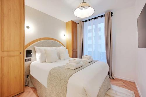 une chambre avec un lit avec des serviettes dessus dans l'établissement Serene apartment - 2BR 6P - Grenelle - Tour Eiffel, à Paris
