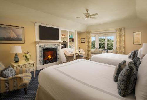 a hotel room with two beds and a fireplace at Chatham Bars Inn in Chatham