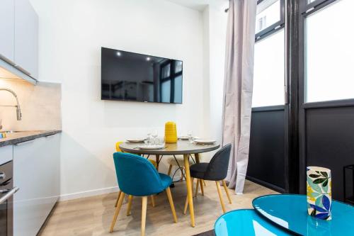 une salle à manger avec une table et des chaises et une télévision dans l'établissement Intimate apartment - 1BR-4P - Republique, à Paris