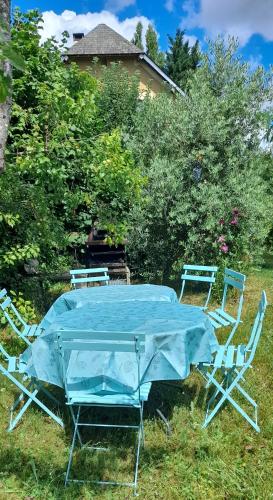 a blue table and chairs in the grass at Guernazelles in Le Controis En Sologne