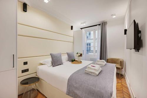 une chambre blanche avec un lit et une fenêtre dans l'établissement Amazing Apartment - 2BR-6P - Gare Saint-Lazare, à Paris
