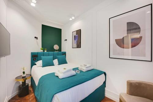- une chambre avec un lit bleu et blanc et une chaise dans l'établissement Amazing Apartment - 2BR-6P - Gare Saint-Lazare, à Paris
