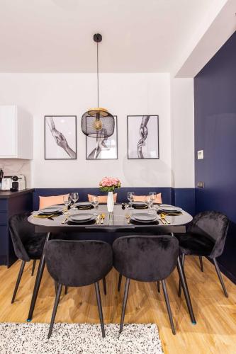 une salle à manger avec une table et des chaises noires dans l'établissement Spacious Apartment- 2BR-6P - Porte Saint-Denis, à Paris