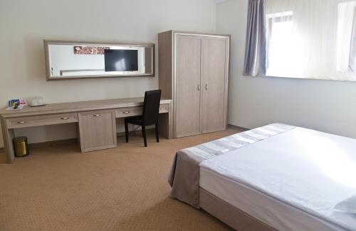 a hotel room with a desk and a bed at Euro Hotel Grivita in Bucharest