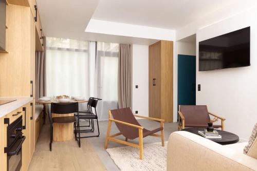 un salon avec un canapé et une table avec des chaises dans l'établissement Elegant Apartment - 3BR-8P - Bastille-Oberkampf, à Paris