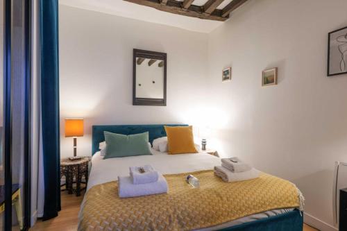 une chambre avec un lit avec des serviettes dessus dans l'établissement Spacious apartment - 2BR-6P - Bastille, à Paris
