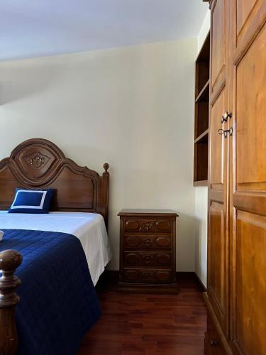 a bedroom with a bed and a wooden dresser at Casa Dentro da Vila in Ponte de Lima