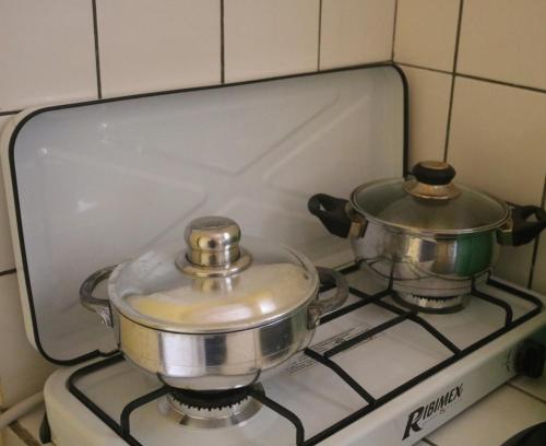 two pans sitting on top of a stove at Appartement à 15min de belles plages in Sainte-Rose