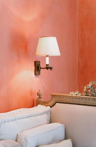 a lamp sitting on a wall next to a couch at Bastide Rose in Le Thor