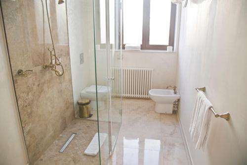 a bathroom with a glass shower and a toilet at Euro Hotel Grivita in Bucharest