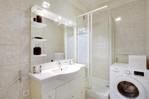 une salle de bain avec un lavabo et une machine à laver dans l'établissement Peaceful apartment 2BR-4P - Arc de Triomphe, à Paris