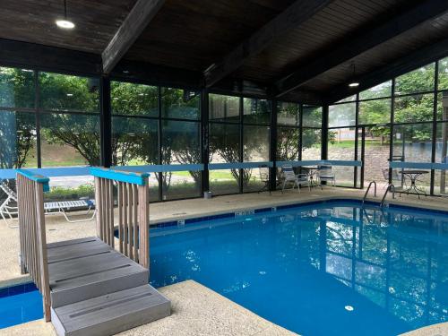 a swimming pool in a building with a house at Pine Lake Resort and Banquets in LaPorte