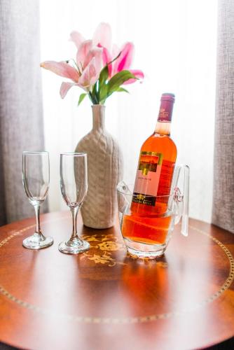 a bottle of whiskey and two glasses on a table at El Principe Hoteles in Piura