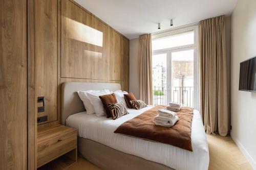 une chambre avec un grand lit avec une fenêtre dans l'établissement Elegant apartment - 3B 6P - Eiffel Tower, à Paris