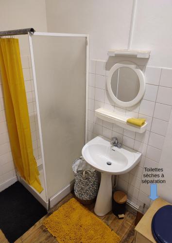 une petite salle de bain avec un lavabo et un miroir dans l'établissement L'Aile Ouest en permaculture, à Bergerac