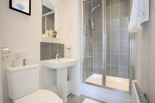 a bathroom with a shower and a toilet and a sink at Prime Location - 4 Bedroom 3 Bathroom House - Sleeps up to 8 - Free Parking, Fast Wifi, Balcony, Smart TV and Private Garden by Yoko Property in Milton Keynes