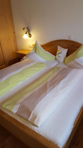 a bed with green and white sheets and pillows at Gasthof Bad Sonnenberg in Nüziders