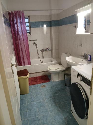 a bathroom with a tub and a toilet and a sink at Ελένης apartment in Gythio