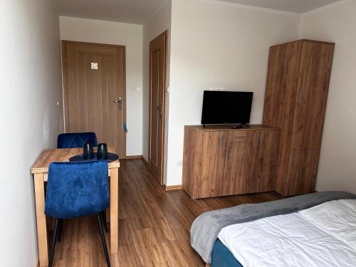 a bedroom with a desk and a bed and a television at Willa Wioletta in Tylmanowa