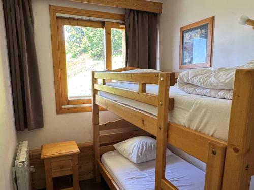 deux lits superposés dans une chambre avec fenêtre dans l'établissement Appartement spacieux au pied des pistes avec piscine, sauna et balcon, Belle Plagne. - FR-1-181-2812, à La Plagne Tarentaise