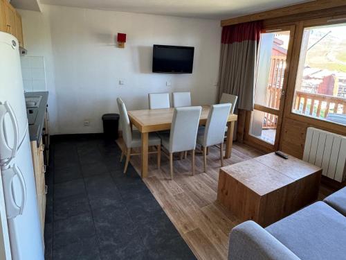 une cuisine et une salle à manger avec une table et des chaises dans l'établissement Confortable 3 Pièces au Pied des Pistes - Piscine, WiFi et Animaux Admis - FR-1-181-2817, à La Plagne Tarentaise