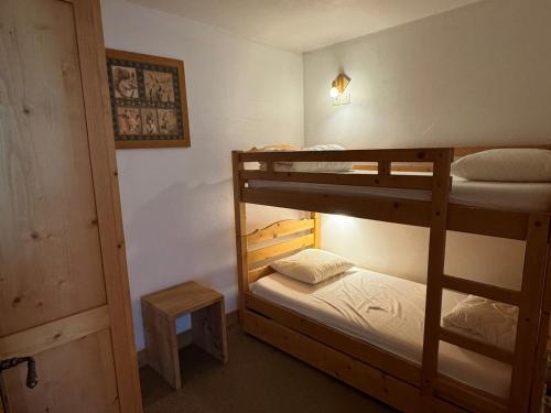 une chambre avec deux lits superposés et une lampe dans l'établissement Confortable 3 Pièces au Pied des Pistes - Piscine, WiFi et Animaux Admis - FR-1-181-2817, à La Plagne Tarentaise