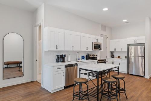 a kitchen with white cabinets and a table and chairs at The Corbin 1302 - The Yale in Fort Worth