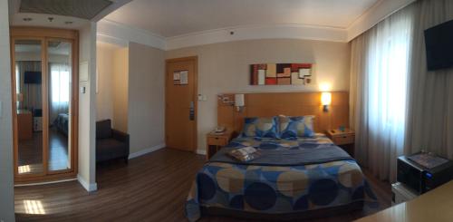 a hotel room with a bed in a room at Slaviero1411 in Guarulhos
