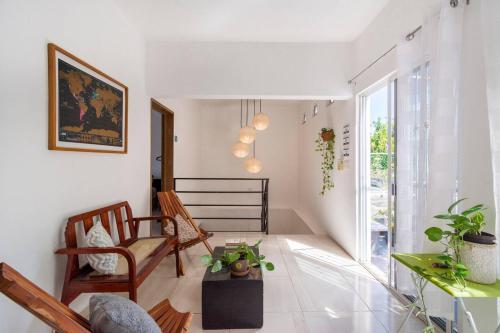 a living room with white walls and a large window at Carlota Guest House in Cozumel