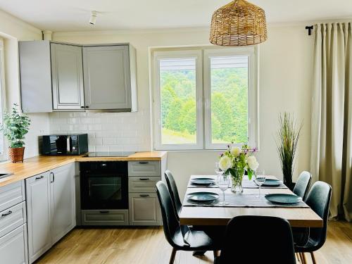 a kitchen with a table with chairs and a dining room at Bukowe Tarasy in Wetlina