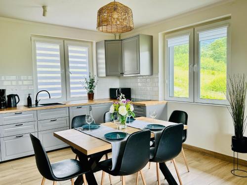 a kitchen with a table and chairs in a kitchen at Bukowe Tarasy in Wetlina