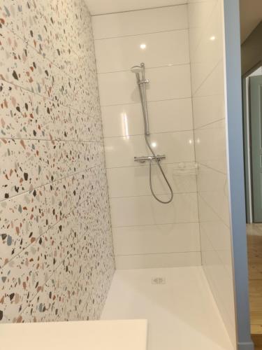 La salle de bains est pourvue d'une douche et d'une paroi en verre. dans l'établissement Le Nid du Bosquet, à Issoire