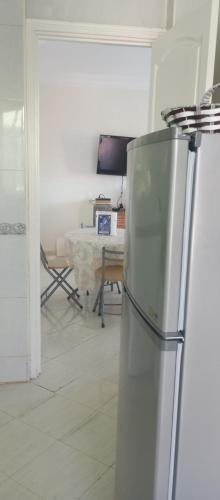 a white kitchen with a refrigerator and a table at Cup Afrique 2025 in Asilah