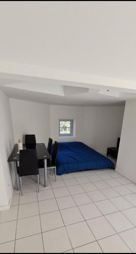 une chambre avec un lit, une table et des chaises dans l'établissement Studio climatisé proche CHU, à Saint-Étienne