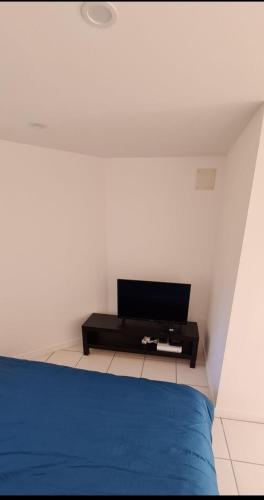 - une chambre avec un lit bleu et une table dans l'établissement Studio climatisé proche CHU, à Saint-Étienne