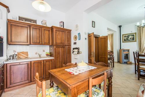 a kitchen with wooden cabinets and a wooden table at MARIA HOLIDAY HOMES La Pineta di Sinalunga in Sinalunga