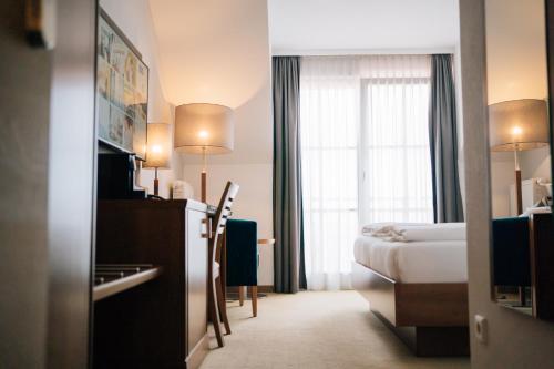 a hotel room with a bed and a window at Klostermaier Hotel & Restaurant in Icking