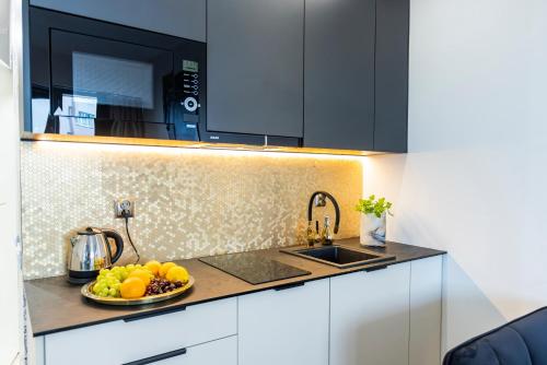a kitchen with a bowl of fruit on a counter at Kaleo apartments - Hanza Tower in Szczecin