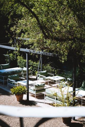 a group of tables and chairs under a tree at Bastide Rose in Le Thor