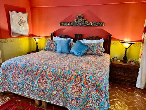 a bedroom with a large bed with blue pillows at Boutique Hotel Casa Camellia in San Miguel de Allende