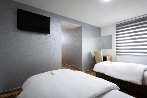 a hotel room with two beds and a flat screen tv at Restoran & Motel Manjež in Bijelo Polje