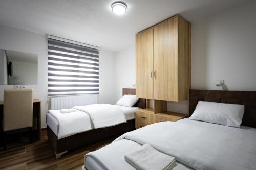 a small room with two beds and a cabinet at Restoran & Motel Manjež in Bijelo Polje
